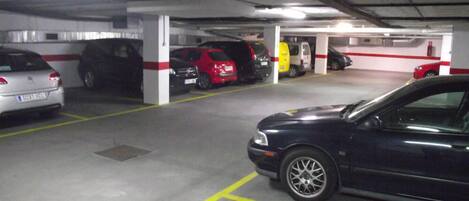 En parkeringskælder med flere etager og biler parkeret på de angivne pladser.