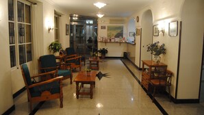 Una hall d'albergo con arredi in legno, una reception e un'ampia finestra.