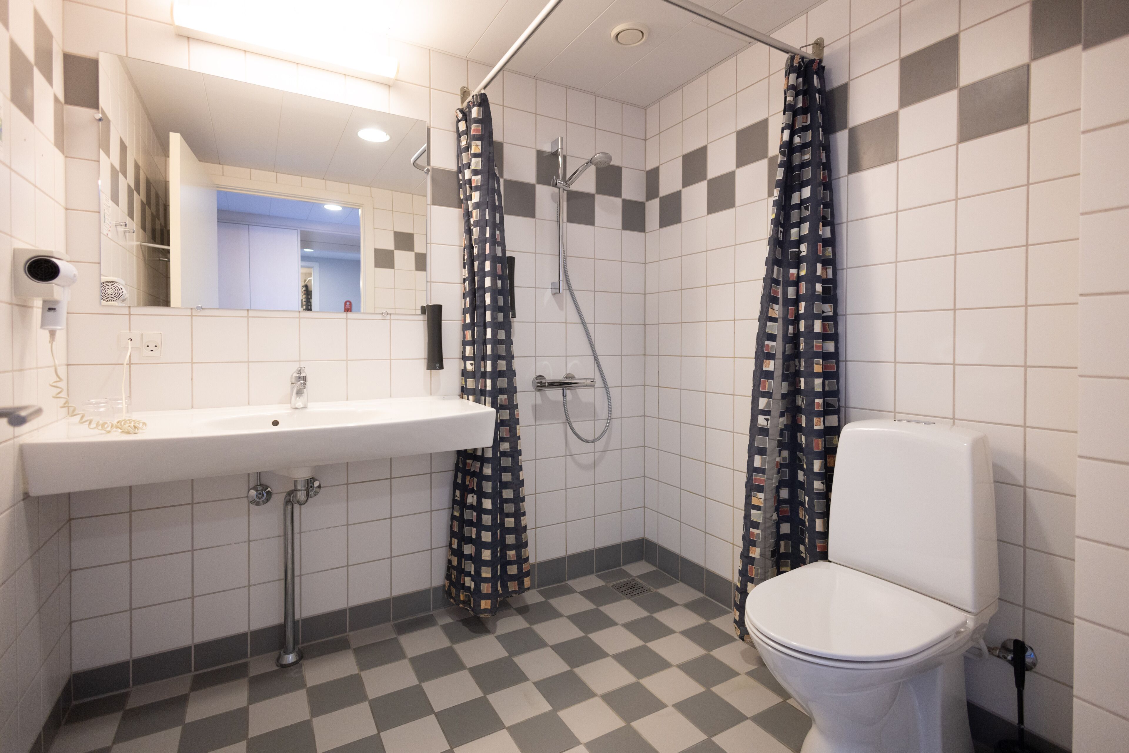 A bathroom with a sink, toilet, and shower.