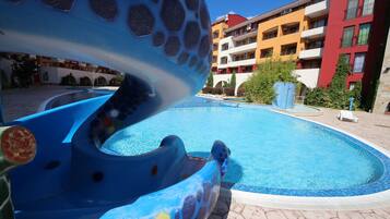 Relax by the pool surrounded by a hexagonal deck and a colorful water slide.