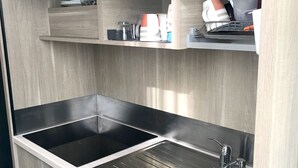 Eine moderne Küche mit zwei Edelstahl-Spülen, einem Einbauofen und einem Geschirr-Abtropfgestell.