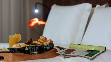Un plateau de petit-déjeuner soigneusement préparé, avec des croissants, un verre de jus d’orange et un journal, posé sur un lit aux draps et aux oreillers blancs.