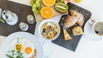 Desayuno con huevos, tostadas, fruta y una taza de café.