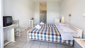 A hotel room with a bed, a television, a small table, and a chair. - Athina (Kefalonia)