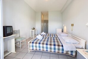 A hotel room with a bed, a television, a small table, and a chair. - Athina (Kefalonia)
