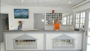A modern kitchen with a white countertop, a large window, and a painting of a sailboat on the wall. - Athina (Kefalonia)