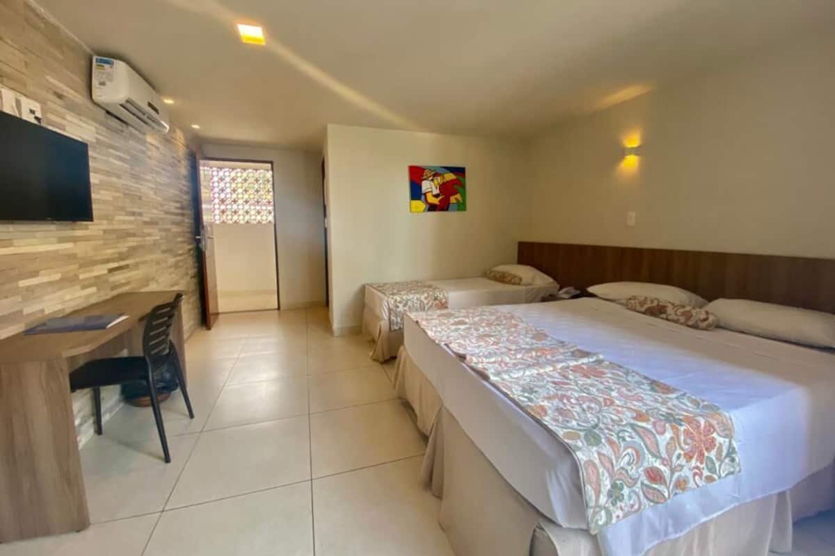 Una camera d'albergo con un letto, una scrivania e una televisione.