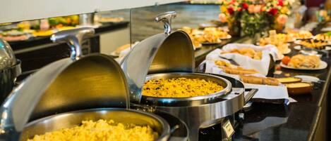 Un bufé con diferentes opciones de comida y un cartel que indica 'Desayuno por tipo de comida'.