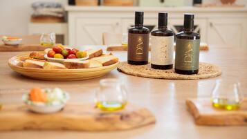A dining table with plates of food, bottles of wine, and glasses.