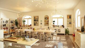 A spacious kitchen with a central island, multiple seating arrangements, and a variety of wine bottles displayed on shelves.