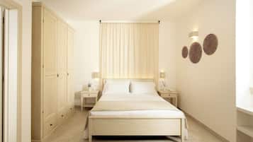 Un dormitorio con una cama grande, un armario, mesitas de noche y elementos decorativos en la pared.
