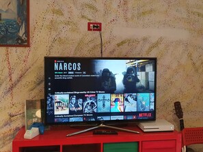 En tv-skärm som visar Netflix-serien ”Narcos”, och på skärmen visas även ett urval av andra program.