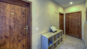 Un pasillo con puertas de madera, un cartel de bienvenida y una consola de madera con libros.
