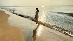 A beach scene with a person walking along the shore. - Saigon Emerald Resort (Mui Ne)
