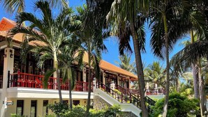 A hotel with a two-story structure, a red balcony railing, and a staircase leading to the upper level. - Saigon Emerald Resort (Mui Ne)