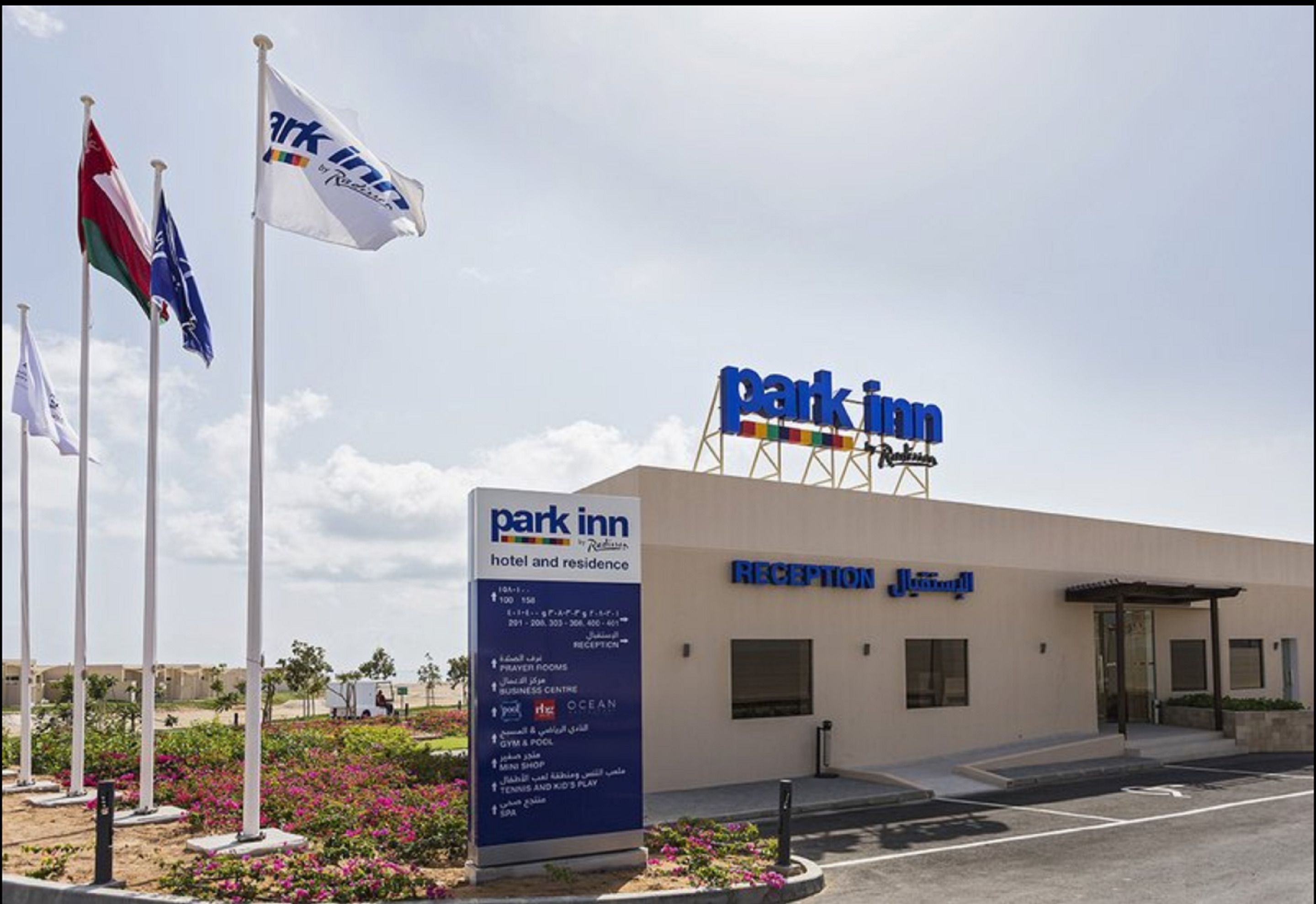 Ett Park Inn-hotell med en reception och en skylt som visar vilka bekvämligheter som finns, till exempel bönerum och ett gym.