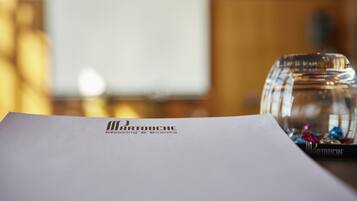 Una cúpula de vidrio transparente cubre una mesa con un logo y texto sobre un papel blanco.