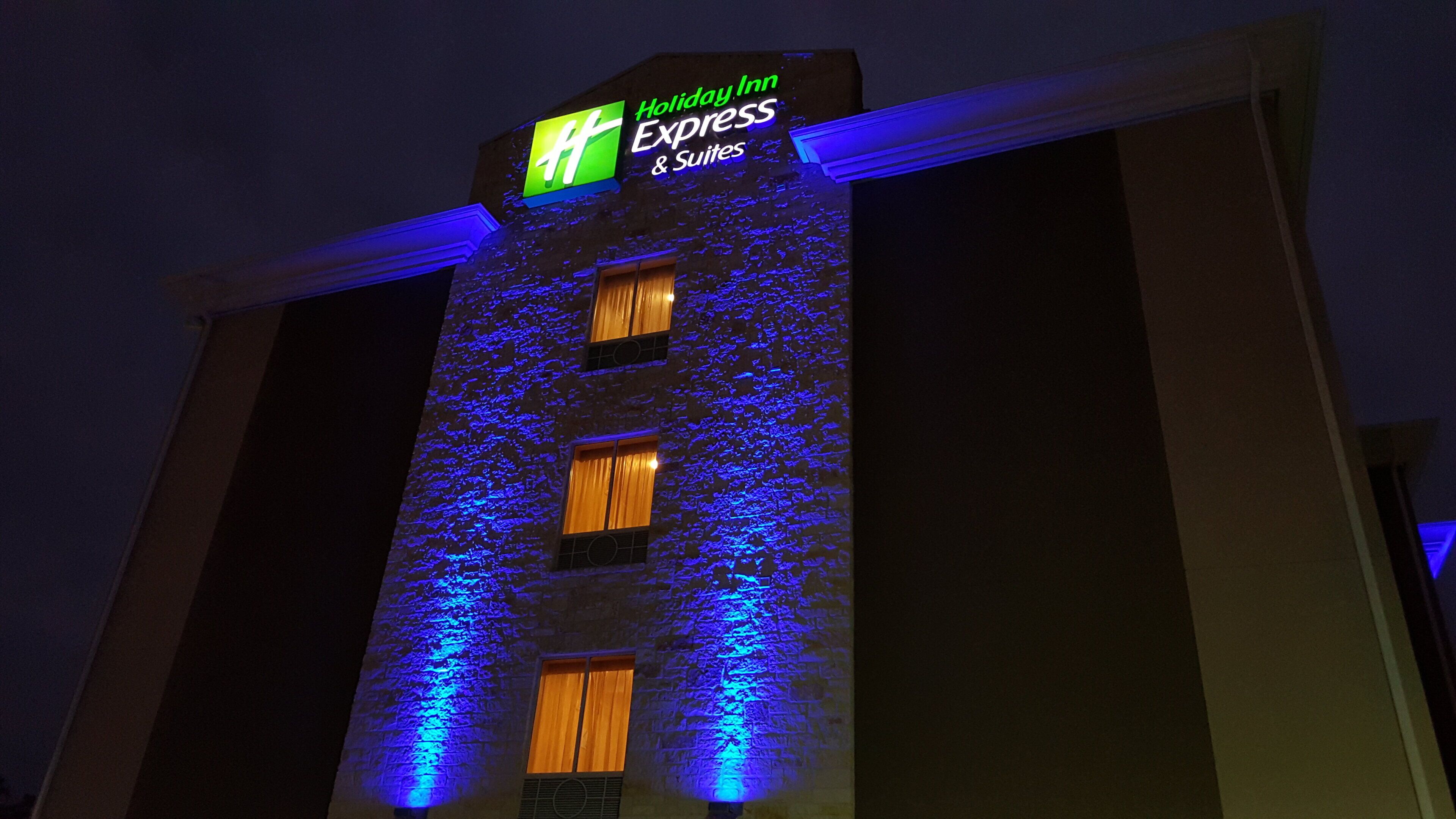 A building with a Holiday Inn Express sign, multiple windows, and a textured facade.