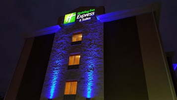 A building with a Holiday Inn Express sign, multiple windows, and a textured facade.