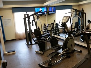 A fitness center with cardio equipment, weight machines, and a mirrored wall. - Holiday Inn Express & Suites Atascocita - Humble - Kingwood by IHG (Humble)