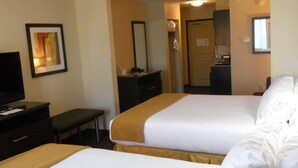 A hotel room with two beds, a desk, a television, and a bathroom visible through an open door. - Holiday Inn Express & Suites Greensburg by IHG (Greensburg)