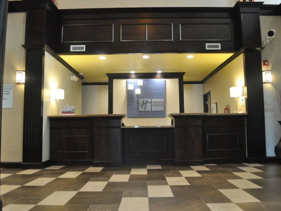 A reception area with a checkered floor, dark wood paneling, and a Holiday Inn Express sign.