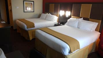 A hotel room with two beds, a desk, and a chair.