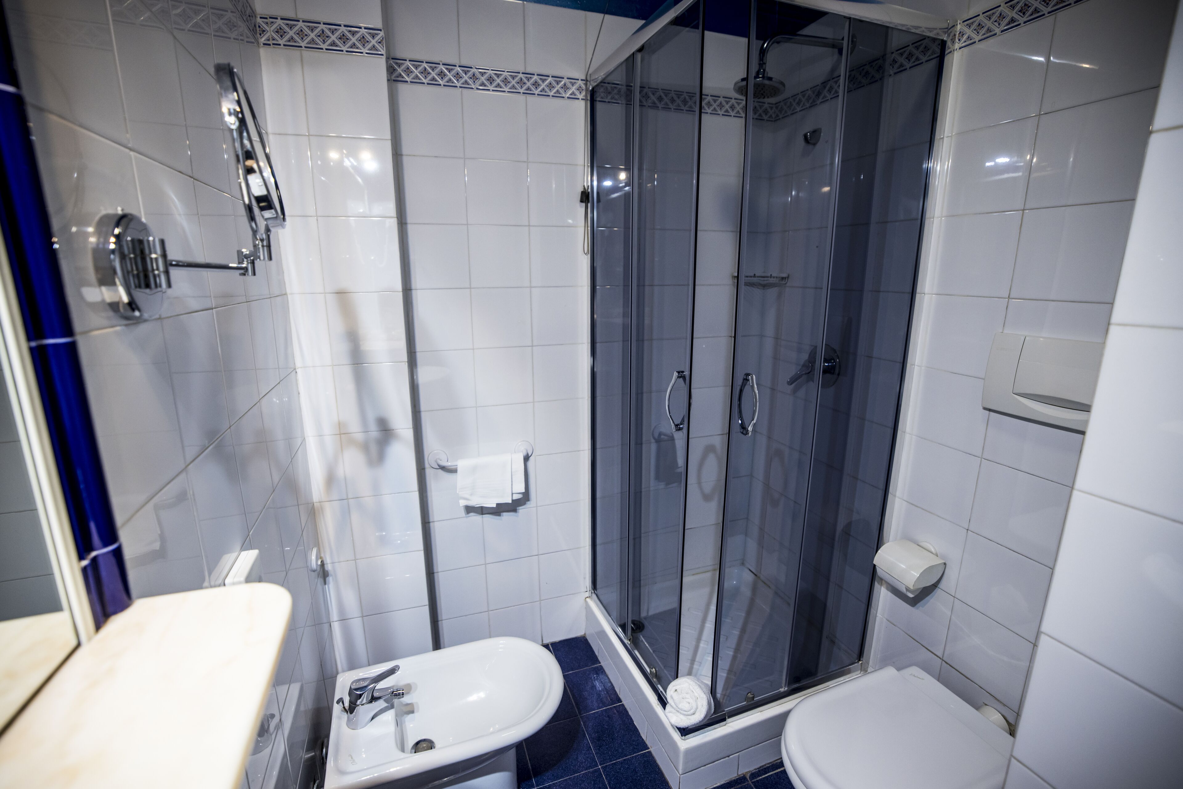 Une salle de bain avec une douche à parois de verre, un lavabo blanc et des toilettes.