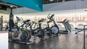 Uma academia com bicicletas ergométricas, esteiras e equipamentos de ginástica.