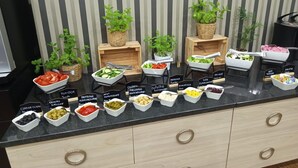 Un comptoir de buffet proposant une variété de plats et agrémenté de petites plantes en pot.