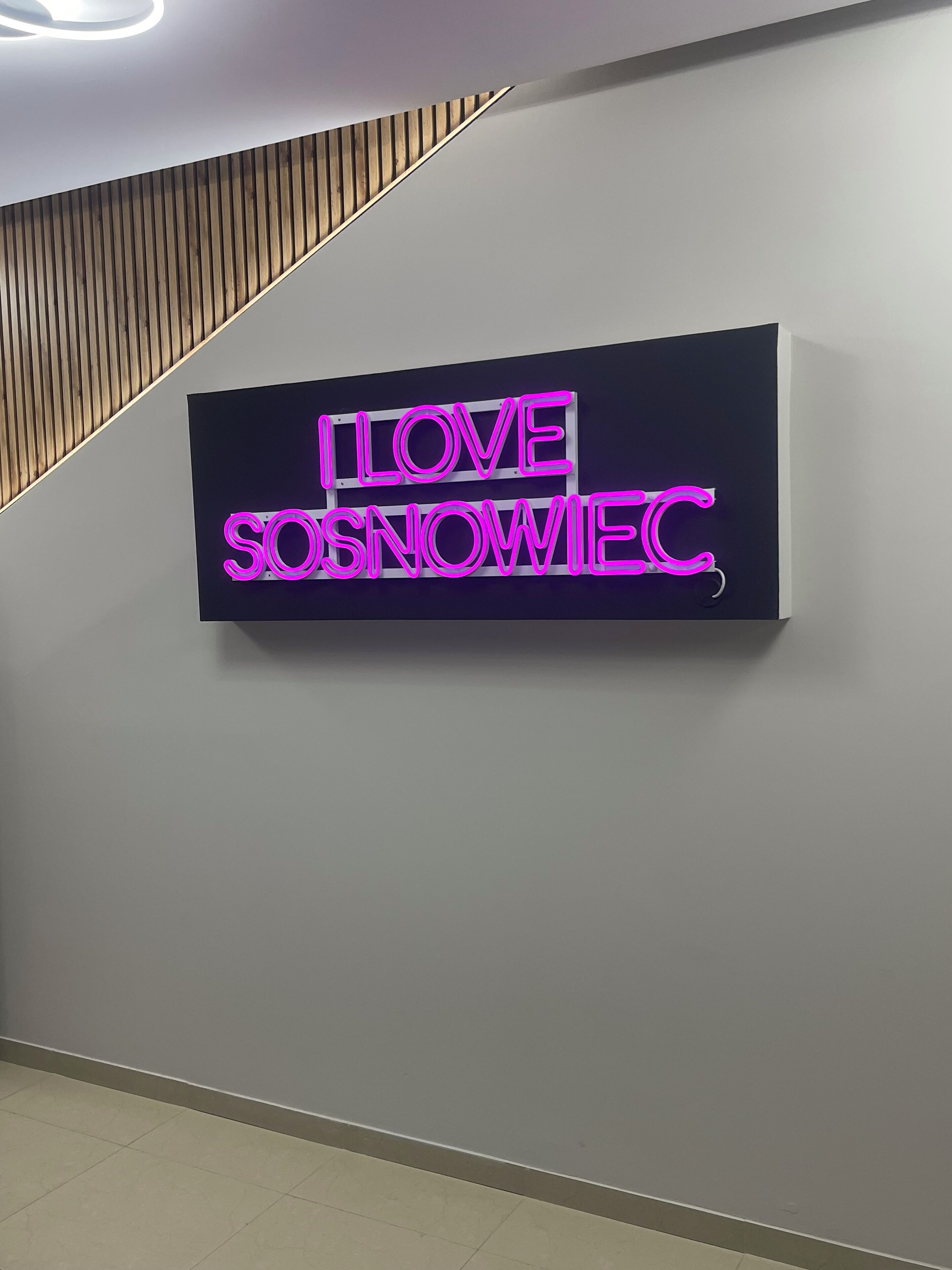 A neon sign on a wall that reads "I LOVE SŁOWIEC."