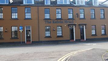 Un edificio de dos plantas con un letrero que dice 'The Kelvin Hotel'.
