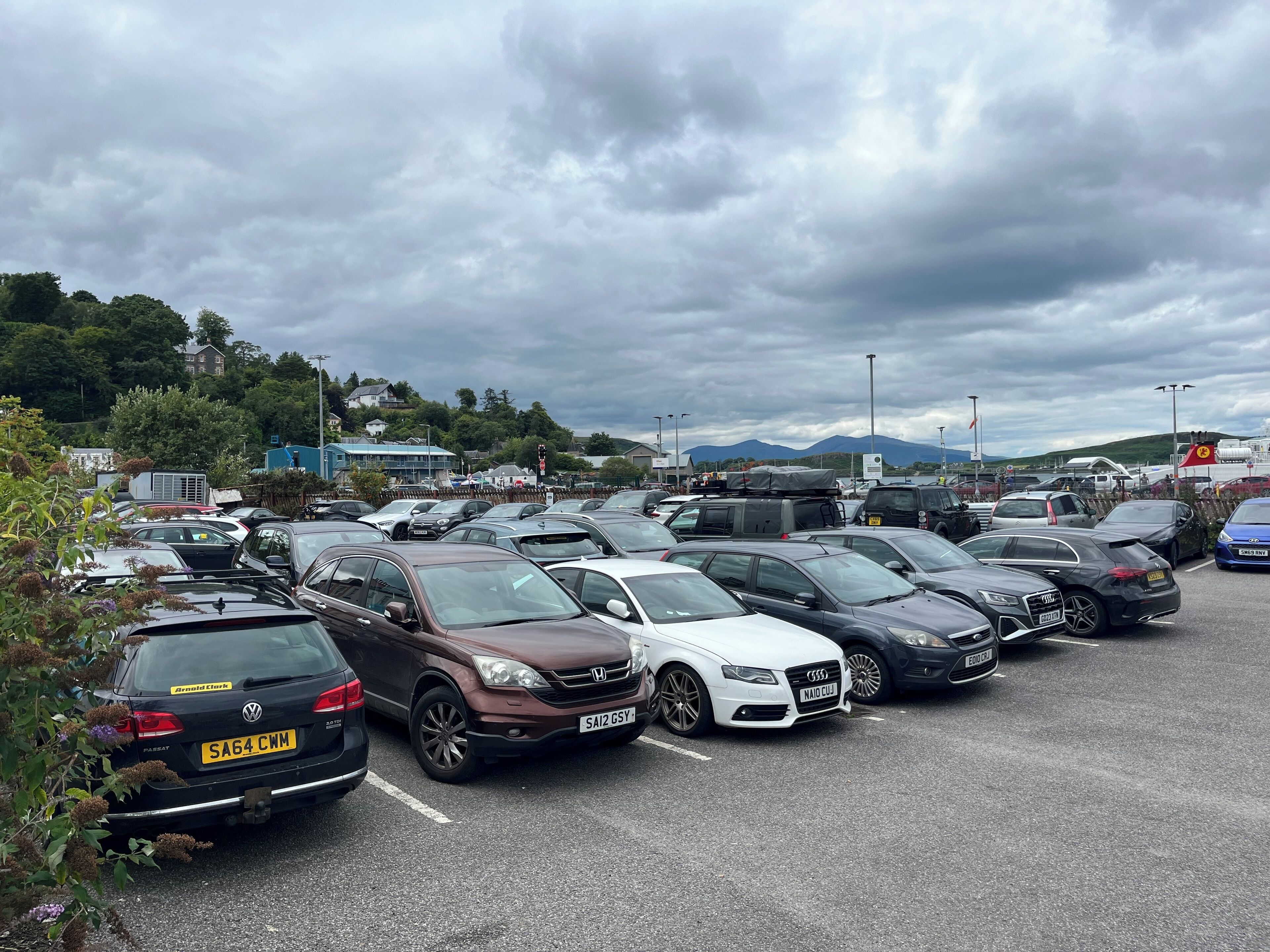 Un parking où sont garées différentes voitures et quelques camions.