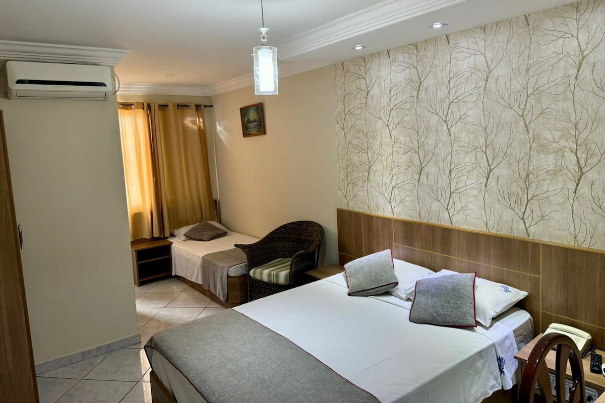Ein Hotelzimmer mit Bett, Schreibtisch, Stuhl, Kleiderschrank und Bad.