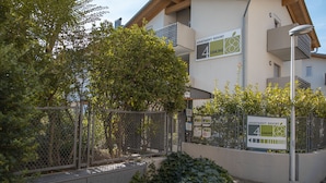 A gated entrance to an apartment resort with a sign indicating the name and a no parking symbol.