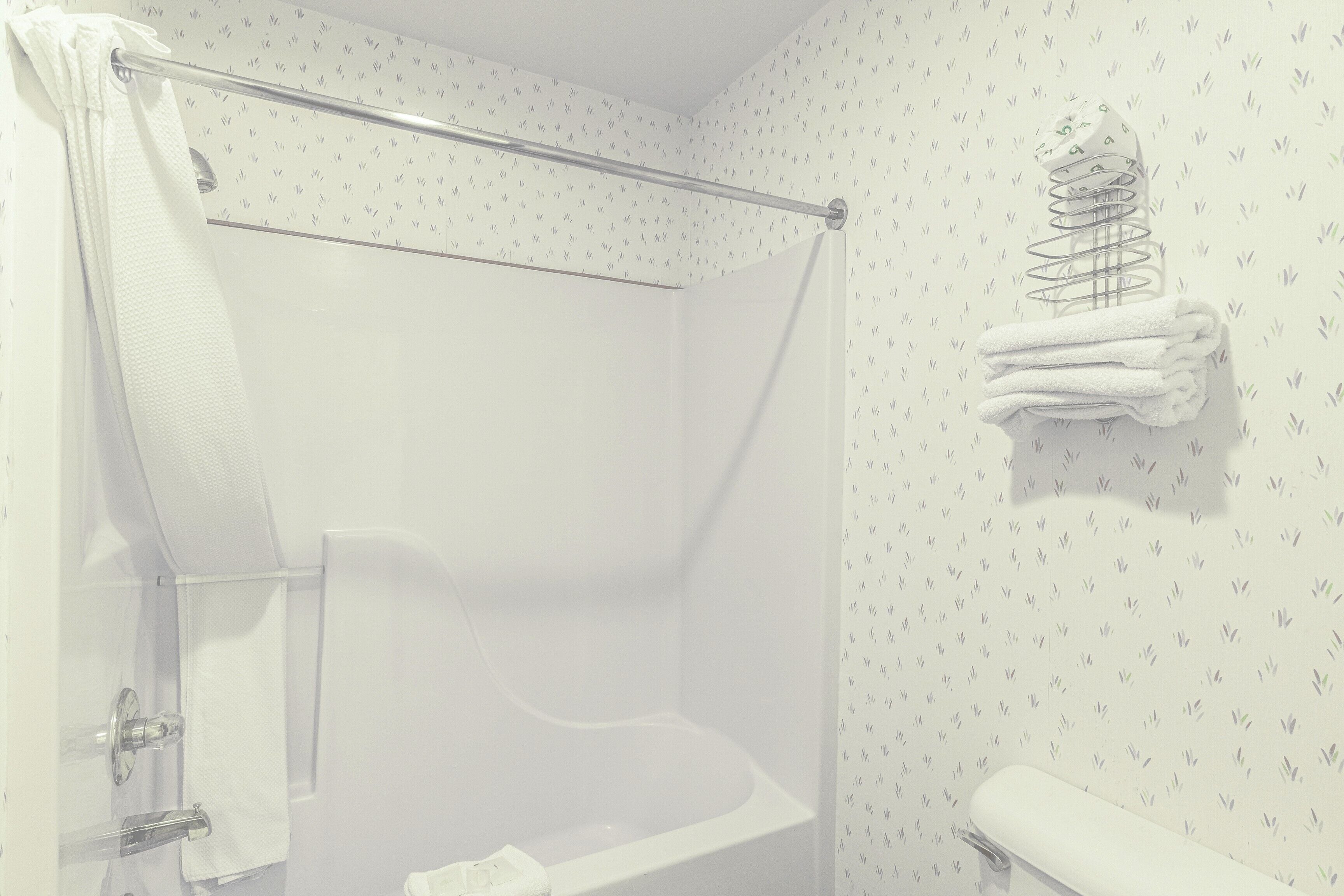 Een badkamer met een douche, een handdoekrek en een toilet.
