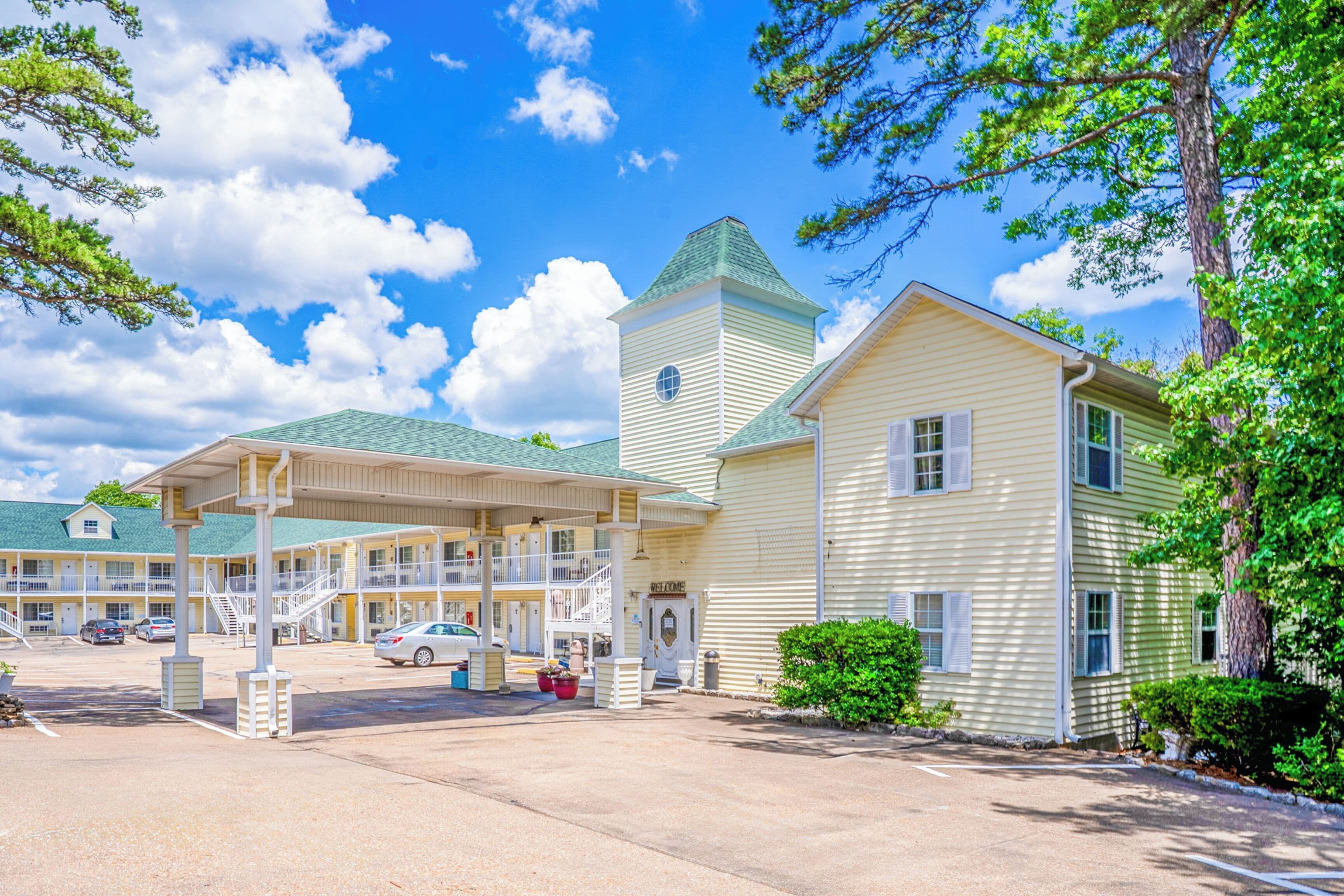 A motel with a central building and a smaller structure with a tower.