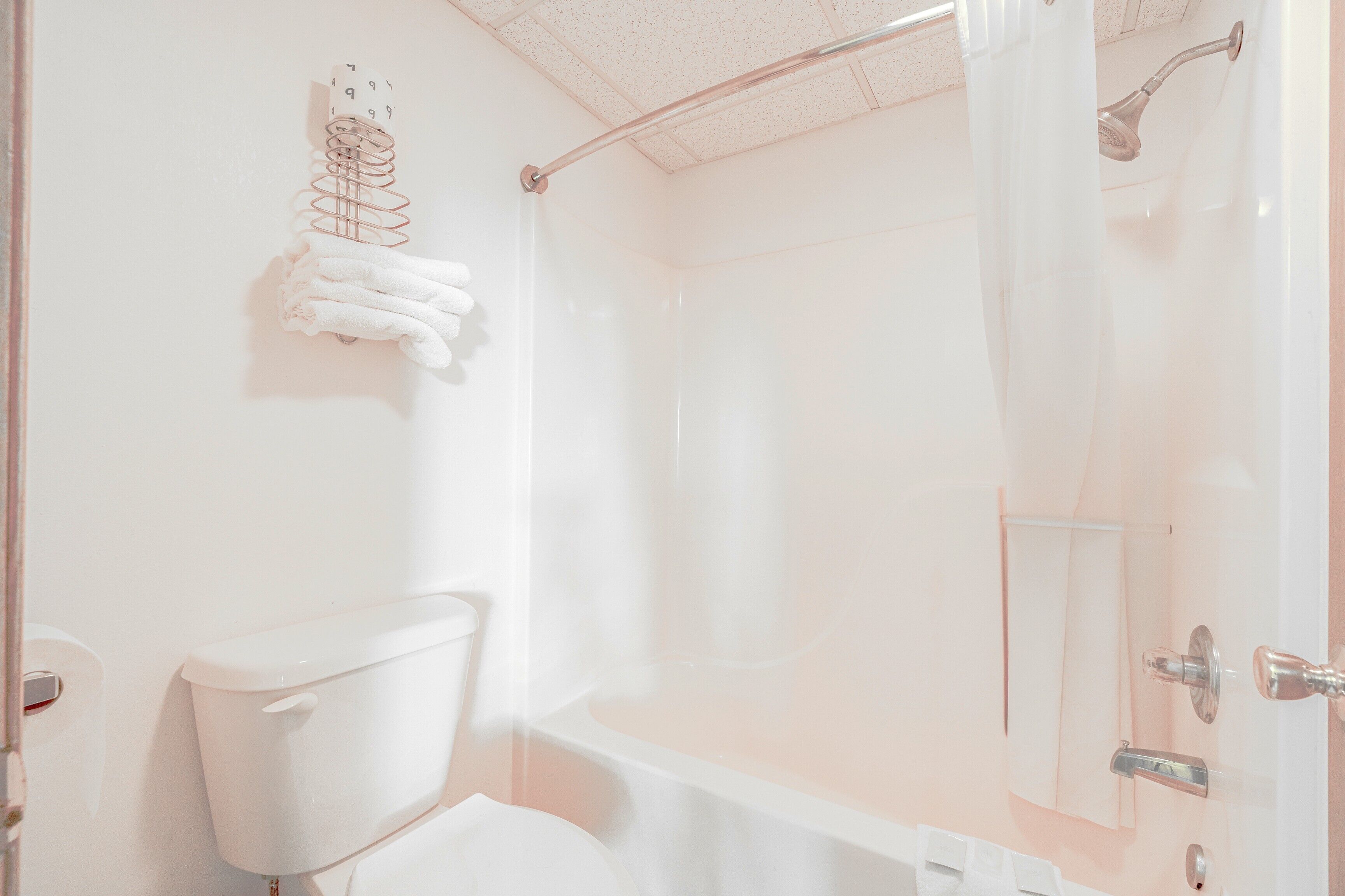 A bathroom with a toilet, a shower with a glass door, and a towel rack with a towel.