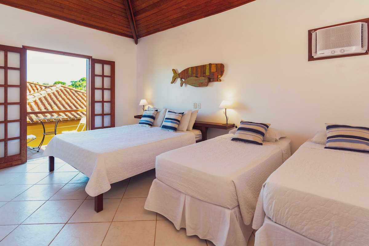 Ein Hotelzimmer mit zwei Betten, einer Fischdekoration an der Wand und Blick auf ein gelbes Gebäude.