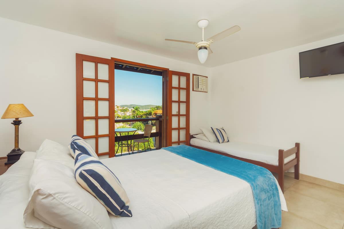 Ein Schlafzimmer mit Bett, Sofa, Fernseher und einem Fenster mit Blick.