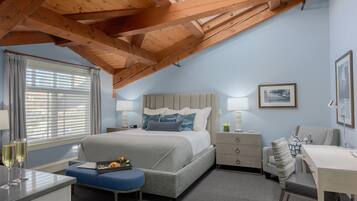 A bedroom with a bed, bedside tables, a desk, and a window with curtains.