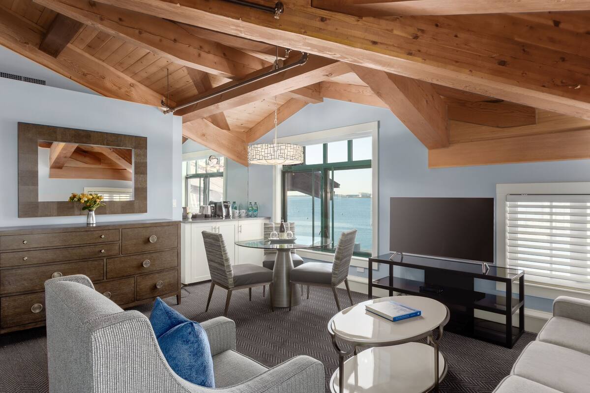 A modern living room with a high ceiling, a dining area, and a TV.
