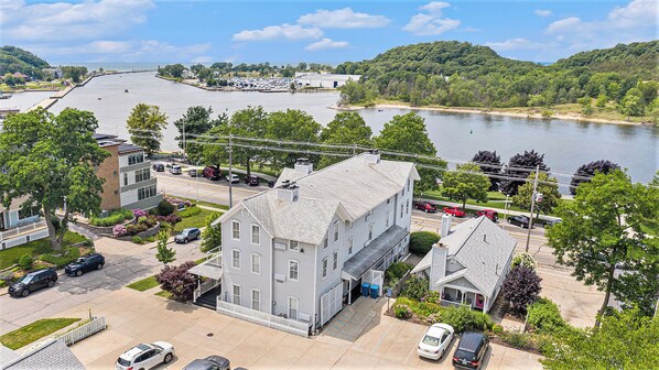 A residential area with a large house, a parking lot, and a body of water in the background. - Harbor House Inn (Grand Haven)