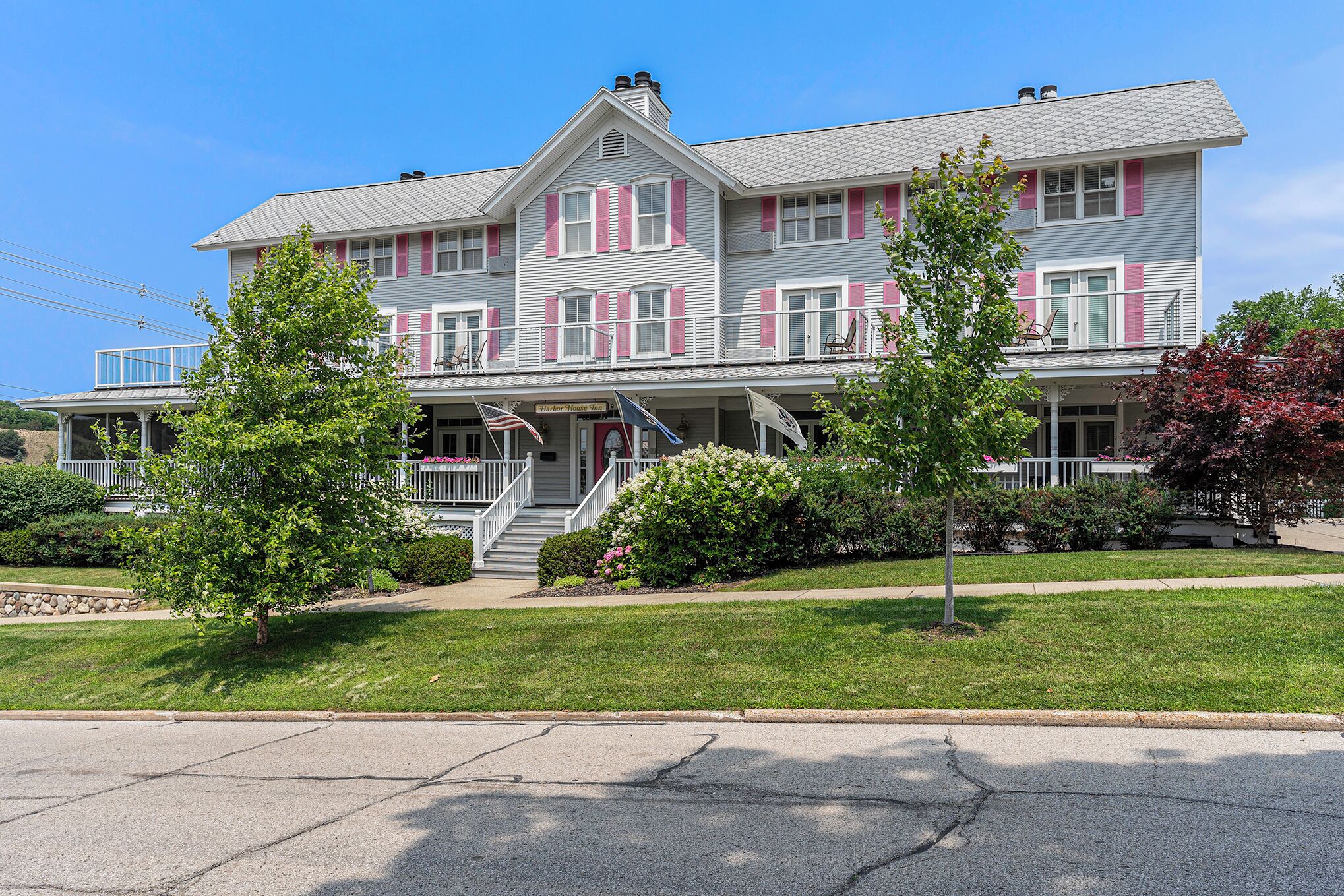 A two-story house with a porch, a staircase, and a small garden.