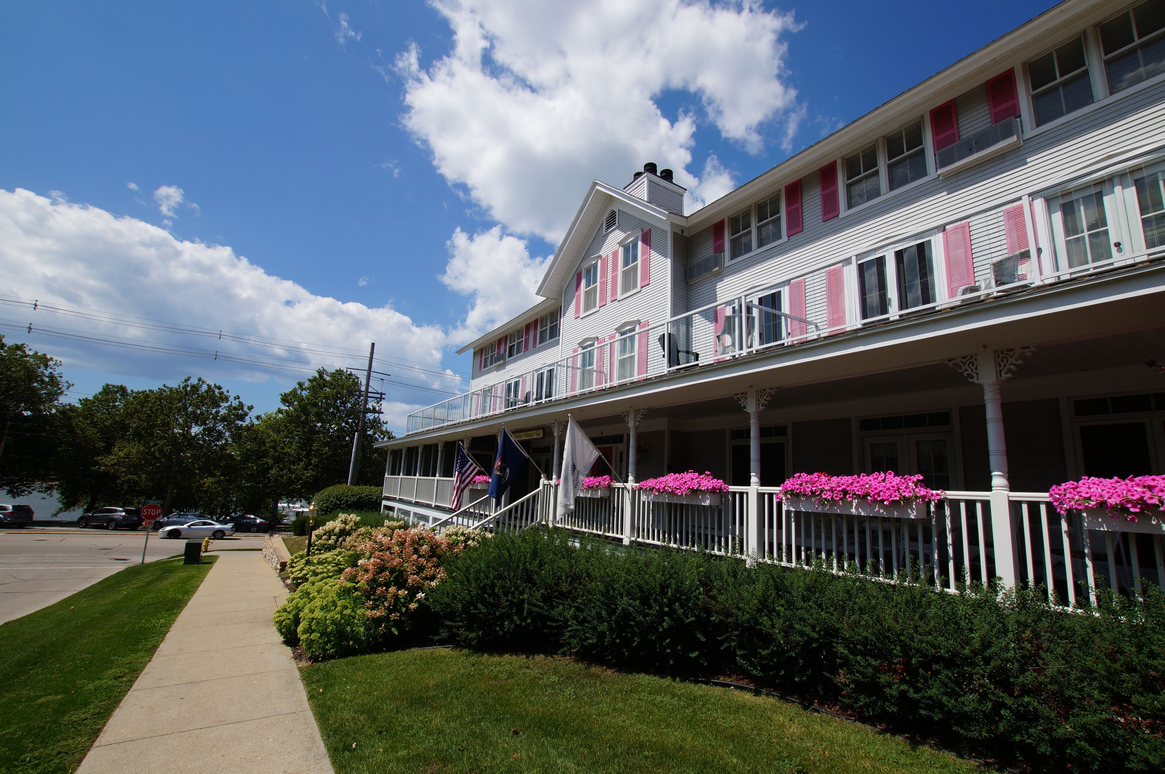 A two-story building with a balcony and a covered porch.