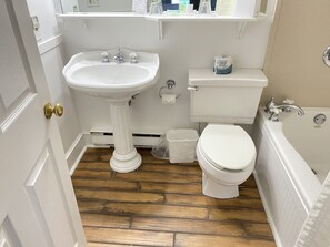 A bathroom with a pedestal sink, toilet, and bathtub.