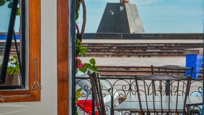 Un restaurante con terraza, mesas y sillas, y vistas a la ciudad.