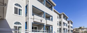 A multi-story hotel with balconies, large windows, and a clear blue sky.