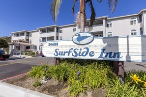 Een SurfSide Inn bord met een logo in strandthema, wat een ligging direct aan het strand aangeeft.