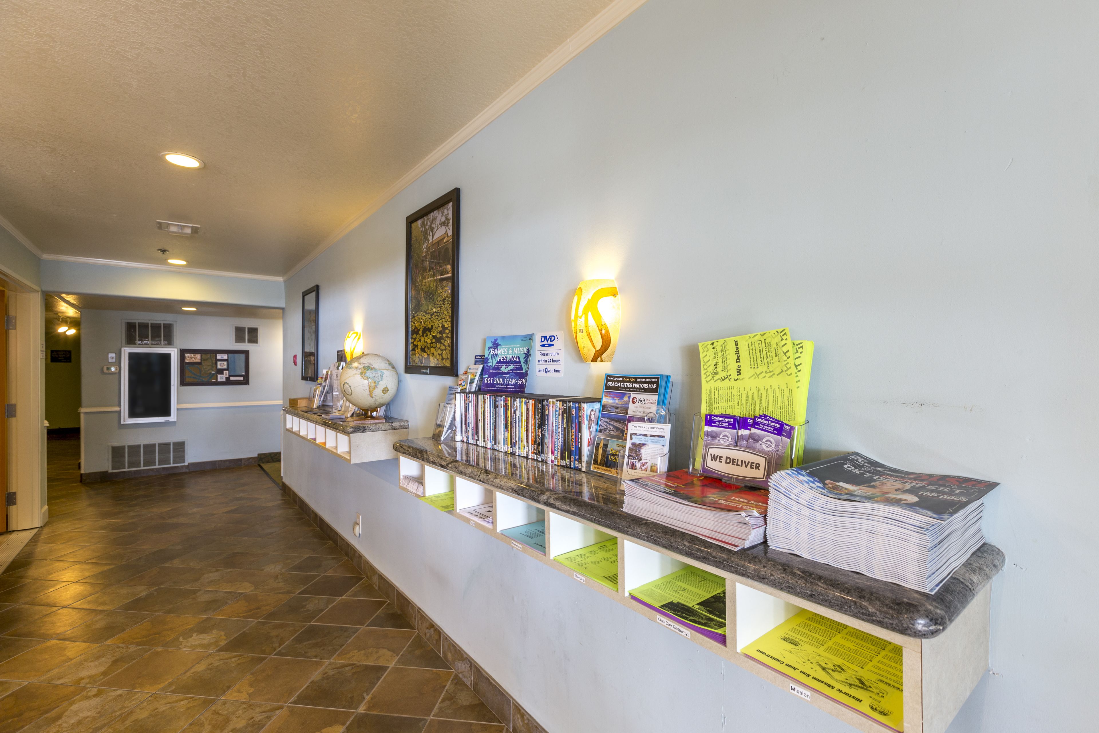 A reception area with a counter displaying various items including magazines, a globe, and informational brochures.